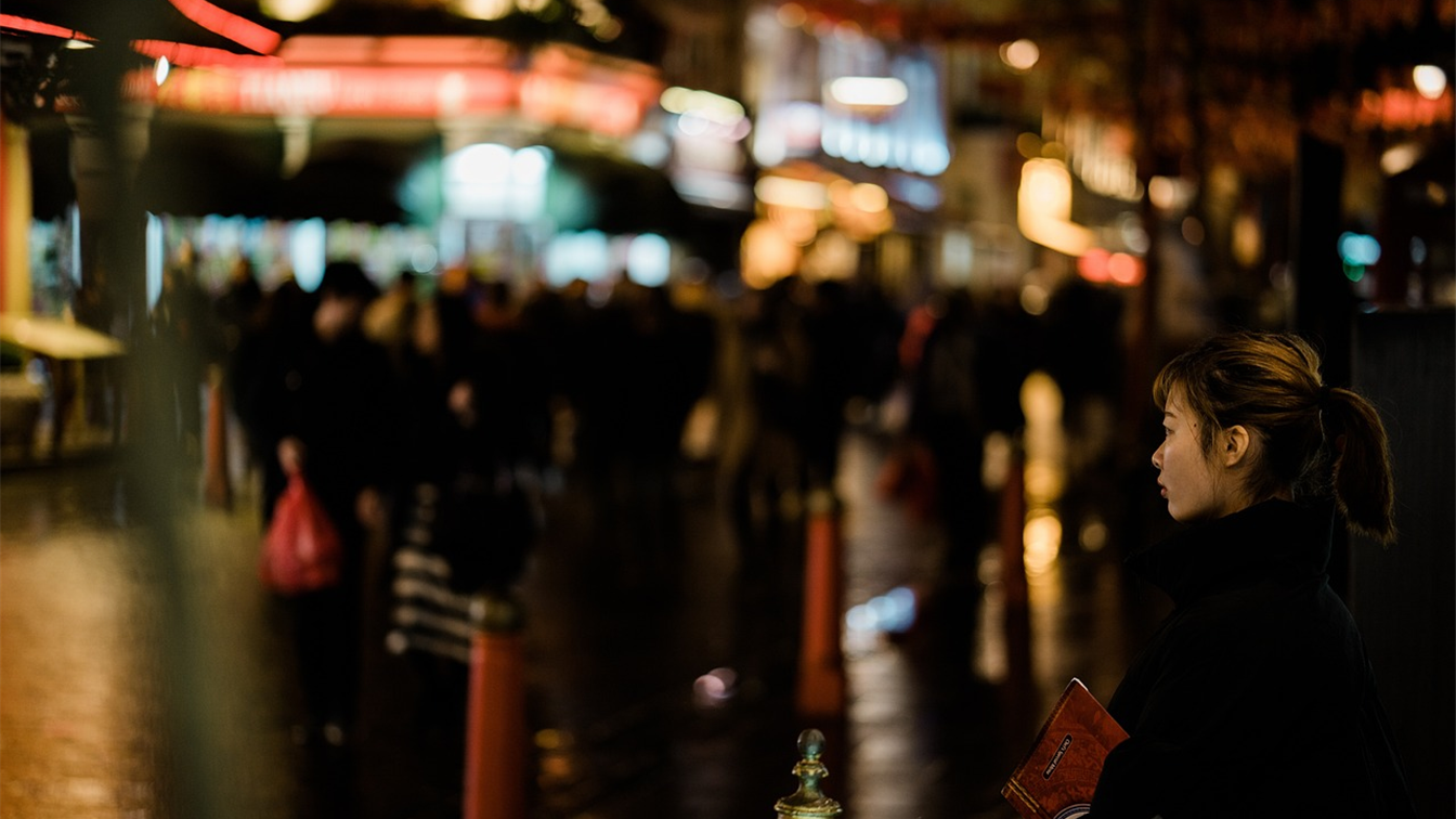 Viajera en una calle animada de noche