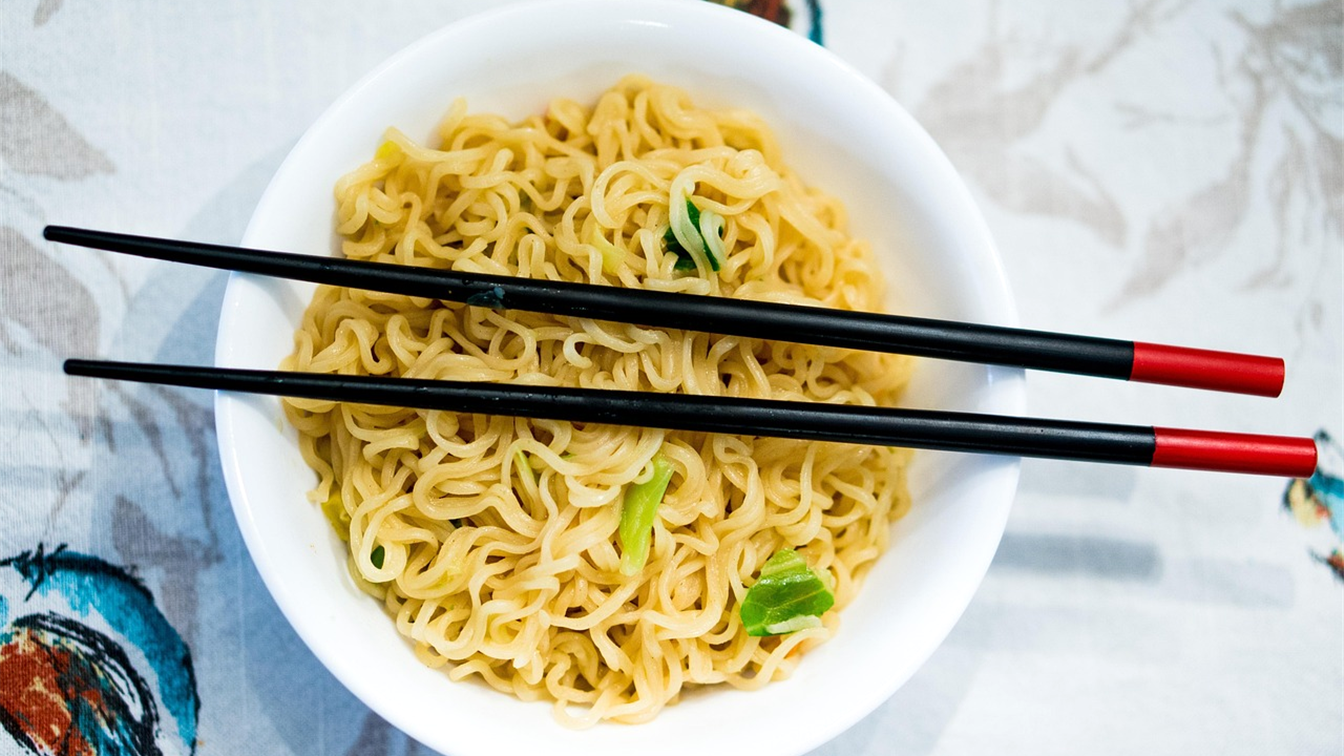Cuenco de fideos con palillos sobre un mantel