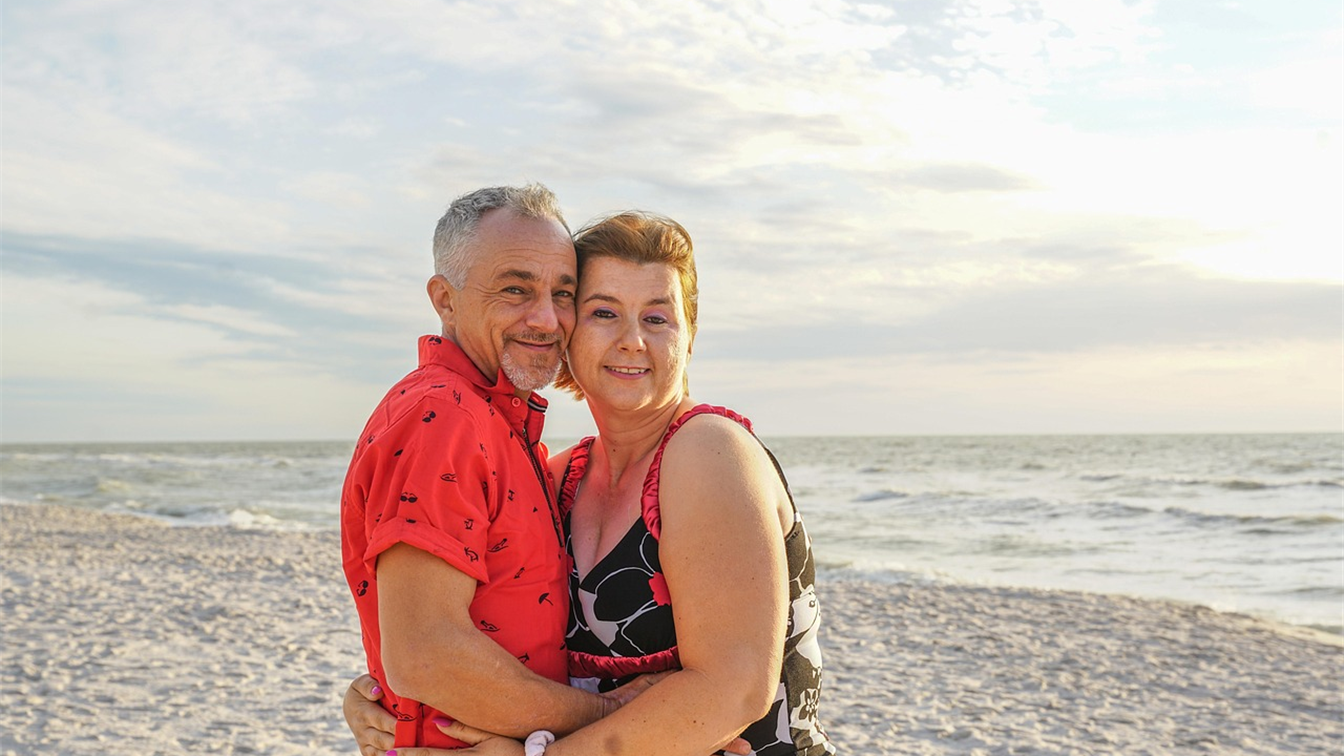 Pareja de viajeros abrazados en una playa al atardecer